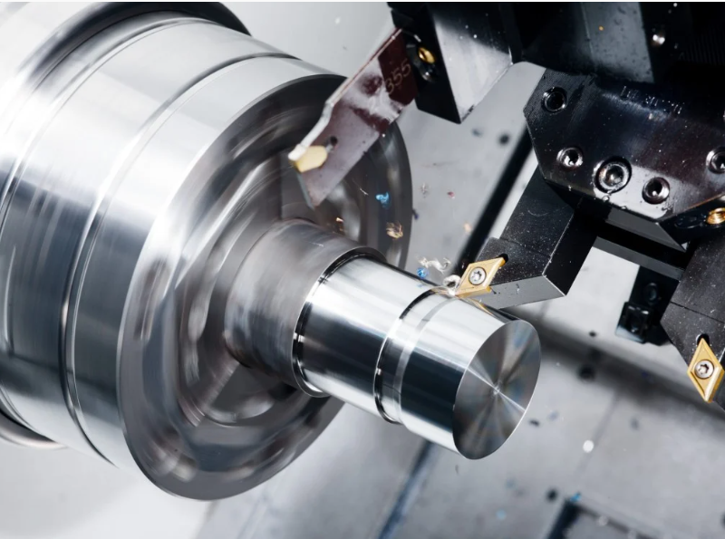 CNC turning machine cutting metal shaft on lathe